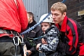 Adam Kutereba helmet and harness on is lifted onto the edge of the top of the black box 