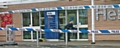 Police forensics dusting the entrance to Tesco for fingerprints