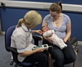 Kristel Bevan, Newborn Hearing Screener for Pennine Care and mum Althea Lyons with five week old baby Isla