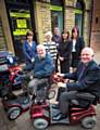 Outside Shopmobility’s new premises in Rochdale town centre are front (left-right) Councillor Allen Brett, Shopmobility Trustee and Councillor Ashley Dearnley, Shopmobility Chairperson. Back (left-right) are Scheme Assistant Michelle Davies; Councillor Janet Darnbrough, Shopmobility Trustee; Jonathan Hindle, Senior Project Manager at Rochdale Development Agency;  Michelle Hollinrake, Shopmobility Manager and Debbie O’Brien, Shopmobility Treasurer