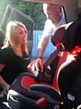 Stuart Howarth demonstrating to Stacey McKler how to properly fit a child safety seat