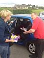 Dave Godley demonstrating to local parent Amy Ingham how to properly fit a child safety seat.