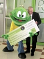 Rochdale Exchange Centre Manager, Lorenzo O’Reilly presents Springy the Hospice Frog with a cheque for £2,000