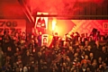 A supporter of FC United of Manchester lights a flare at Spotland Stadium during an FA Cup tie against Rochdale