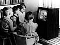 Children gathered around a black and white TV set watching Andy Pandy on the BBC in the 1950s