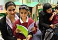 Parents in the new library reading with their children