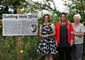 Girlguiding Leaders Martina Caraher (centre) and Ellen Hendry (right) and fellow leader from Bury, Helen McCreadie (left) standing with the Guiding Idol plaque in the NW England Region Headquarters’ garden