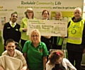 Staff from Asda present a cheque to Rotarian David Acton and staff and students from Redwood School