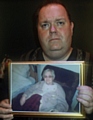 Andrew Oldham with a photograph of his mother, Barbara Oldham