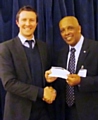 Bobby Cross receiving the cheque from John Holder