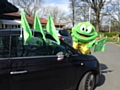 Springy the Hospice Frog decorating cars with Go Green flags