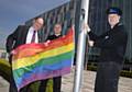 Deputy Police & Crime Commissioner Jim Battle, PCSO Kris Lysaght from the North Manchester Division and Special Constabulary Chief Officer Mike Walmsley raise the flag outside FHQ. 