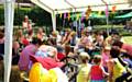 Parents and children gather round for story-time in the park