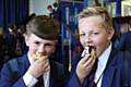 Harrison Smith and Luke Chadwick, both 12, tuck into cakes bought at the Macmillan Coffee Morning at Whitworth Community High School