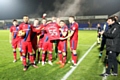 Rochdale players celebrate victory with Joshua McCormack's squad shirt