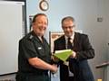 Steve Evans at the retirement presentation with NWAS Head of Driving Standards Paul Jones-Roberts