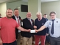 Rochdale RUFC club captain Tom Callaghan, Chairman Iain Coates and President Steve Helliwell present a cheque for £1000 to the Carlisle captain and president 