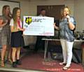 U13s Pink Warriors present a cheque to State of Mind trustee Clair Carson