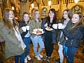 Chelsea Hughes (middle, holding the full cake) surrounded by some of her friends and helpers