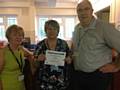 Carole Hill (centre) receiving a cheque from Rotarians Janice Powell and Ged Heatherington