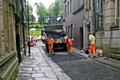 Workmen put temporary tarmac where the setts have been removed on King Street