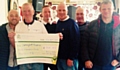 Landlord Paul Quinn holding the cheque, and Bulls Head regulars