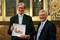 Sir Bill Cash is presented with a commemorative plaque by MP Tony Lloyd