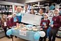 Co-op store manager Ben presents Whittaker Moss Headteacher Melanie Backhouse and Business Manager Dorita Stevenson and some pupils with the cheque