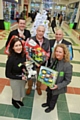 Rochdale Exchange staff in front of the tree with gifts