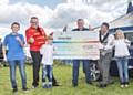 Swansway Group Director David Smyth presenting the cheque assisted by his children, George, Henry and Francesc