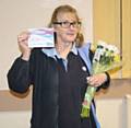 Janet Selby with her 30 years’ service certificate and flowers