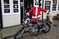 Santa with his motorcycle ready to deliver a sack of toys to the women's refuge