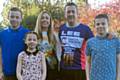 Lee Doherty in his CRUK running vest with wife Emma and children Joshua, 12, Megan, 8 and Rhys, 11.