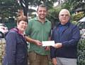 Paul Ellison receiving a cheque towards the equipment from  Councillor Ray Dutton and Elaine Dutton earlier this year