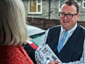 Andy Kelly talking to a resident (in the rain!)