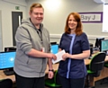 The Rochdale Ear Care Clinic owner Kath Scully presents Kieran Cullinan with a gift reward for his design