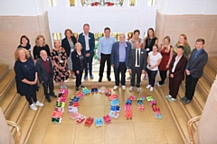 Greater Manchester Health and Care Board and other representatives with £10m spelt out in trainers  