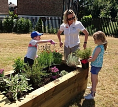 RHS specialist Anne Gunning and child volunteers helping to plant