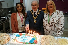 Mayor Billy Sheerin cuts the National Lottery's birthday cake, with Bev Place, business development manager at RCT (right), and a representative from the National Lottery (left)