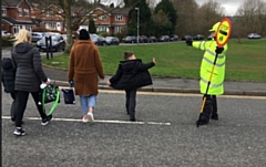 A lollipop man gets a wave from a St Vincents Primary School pupil at the Caldershaw Road crossing in Norden