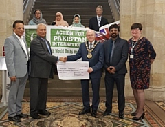 Ghulam Rasul Shahzad OBE, Chairman of Action for Pakistan International, presents Mayor Billy Sheerin with one of the two cheques