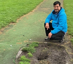 Councillor Faisal Rana inspects the damaged cricket pitch at Lenny Barn