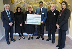 Councillor Faisal Rana and his wife Iram present a cheque to Springhill Hospice