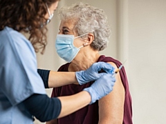 A volunteer administers a Covid vaccine