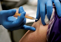 A volunteer administers a Covid-19 vaccine