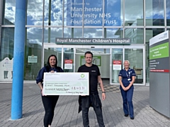 Toni and Lance outside Royal Manchester Children's Hospital with one of their fundraising cheques