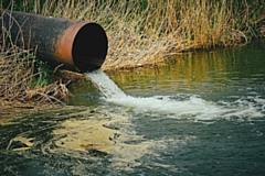 Draining sewage from pipe into river