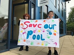 Schoolboys Daley Chianca, left, and William Cromer with a banner about Whitworth Leisure Centre at Rossendale Council. They attend St Bartholomew's School in Whitworth