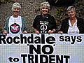 three peace campaigners with the giant placard they will be taking to Faslane.