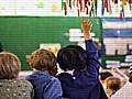 Child with their hand up in a lesson